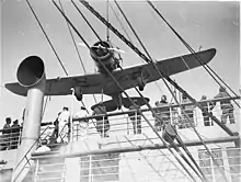 Photographie montrant l'avion pendu à une grue.