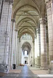 Bas-côté bordé de deux rangées de deux colonnes liés par des tirants de bois