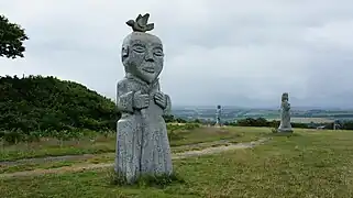 champs dans lequel sont visibles 2 grandes statues modernes.