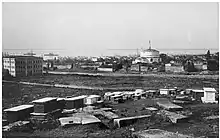 Tombes à l'avant-plan, bâtiments en arrière-plan.