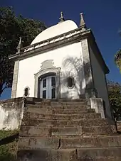 Photographie en couleurs. Vue en contre-plongée d'une chapelle, depuis en bas des marches qui mènent à celle-ci.