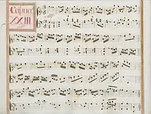 partition manuscrite rehaussée de couleurs passées, rouge et vert en bordures et cadre de titre, titre en rouge