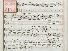 partition manuscrite rehaussée de couleurs passées rouge et vert en bordures et cadre de titre, titre en rouge