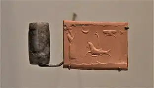 Sceau-cylindre en sardoine sans inscription représentant une scène de culte royal devant des symboles divins. Musée du Louvre.