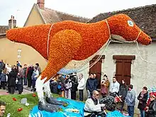 Créature à deux pattes composée de fleurs de couleurs oranges.