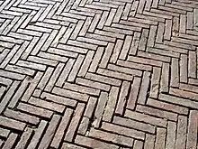 Le sol de la place en briques posées en épi.