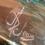 Signature d'Auguste Jean, A. Jean. Émail rouge-brun sur verre. Entre 1877 et 1884.