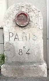 Borne ancienne de la RN301 à Stains, avec un repère de nivellement.