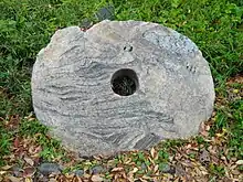 Pierre ovale beige avec des veines ondulées gris sombre