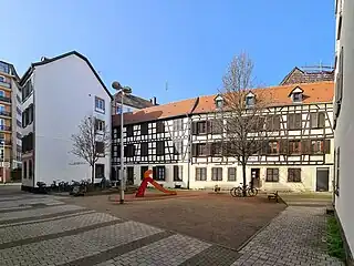 Aire de jeu devant les maisons à pans de bois.