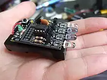 Petite télécommande sans boitier, posée sur la paume d'une main