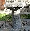 Table de messe en pierre taillée devant la chapelle de la Nativité de la Sainte-Vierge, aujourd'hui devenue une maison.