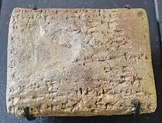 Tablette administrative en ougaritique : texte mentionnant des personnes originaires de Chypre venant prendre des vivres à Ougarit.