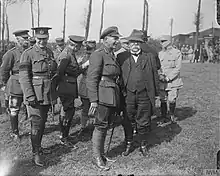 Photo en noir et blanc d'un groupe d'hommes militaires et d'un vieux homme en civile.