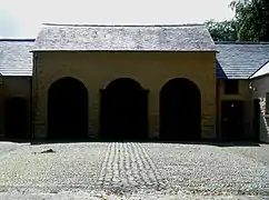 Cour pavée de galets en arête-de-poisson.
