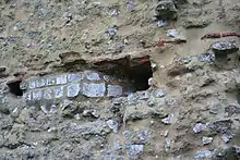 Photographie en couleurs d'un mur percé d'un trou.