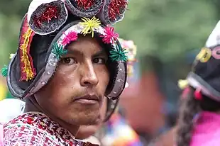 Photographie prise durant le Carnaval d'Oruro représentant la coiffe traditionnelle (montera) utilisée pendant la cérémonie et la danse du Pujllay. Elle mime, par dérision, les casques des conquistadors espagnols du  XVIe siècle. La même coiffe est utilisée pour le combat rituel et la danse du Tinku.