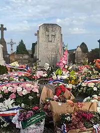 Tombe d'Annette Lajon, le 23 août 2023, couverte de gerbes de fleurs.