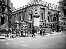 Des soldats érigent des protections à partir de sacs de sable devant un bâtiment