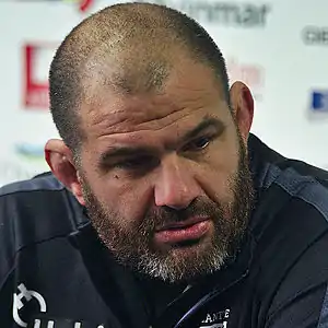 Photographie d'un homme avec un maillot noir vu de trois-quart