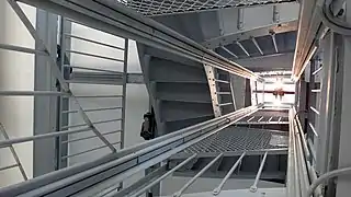 Vue d'une fenêtre sur la terrasse depuis la cage du monte-charge.