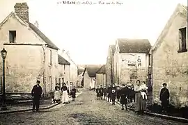 Vue d'une rue au début du XXe siècle ; mairie à gauche et école à droite
