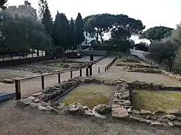 vue des ruines de 2 rangées de maisons hautes de 2 niveaux de pierres sombres