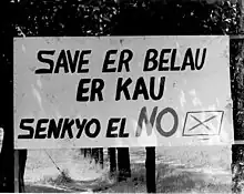 Pancarte blanche avec un texte en lettres noires écrit en paluan