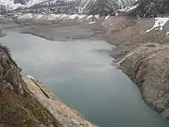 Vue générale du lac de Tignes vide avec les restes du village au fond.