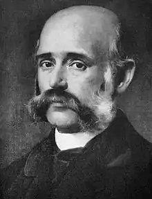 Portrait en noir et blanc d'un homme blanc âgé moustachu.