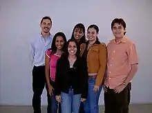 Six personnes jeunes, brunes, posent en souriant.