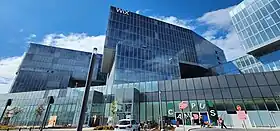 Vue d'un grand immeuble de forme cubique avec un ciel bleu.