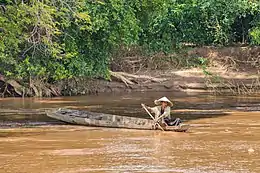 Femme dans sa barque au Laos lors d'une pêche dans le Mékong.