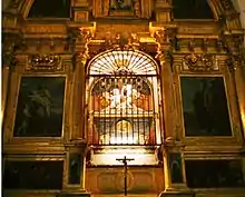 Tombeau ouvragé et éclairé situé dans une église.