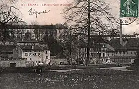 L'hôpital Saint-Maurice dont le clocher est visible derrière la cheminée d'usine à droite ; à gauche le grand bâtiment, plus récent, qui sera épargné par la guerre.