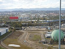 Photographie d'un paysage industriel pris depuis une colline. Au premier plan, une sphère verte d'une vingtaine de mètres de diamètre.